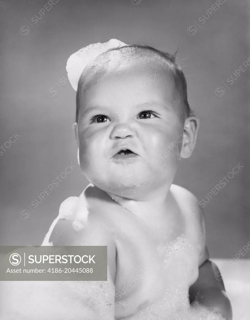1960s CUTE PUGNACIOUS BABY IN BATH COVERED IN SOAP SUDS