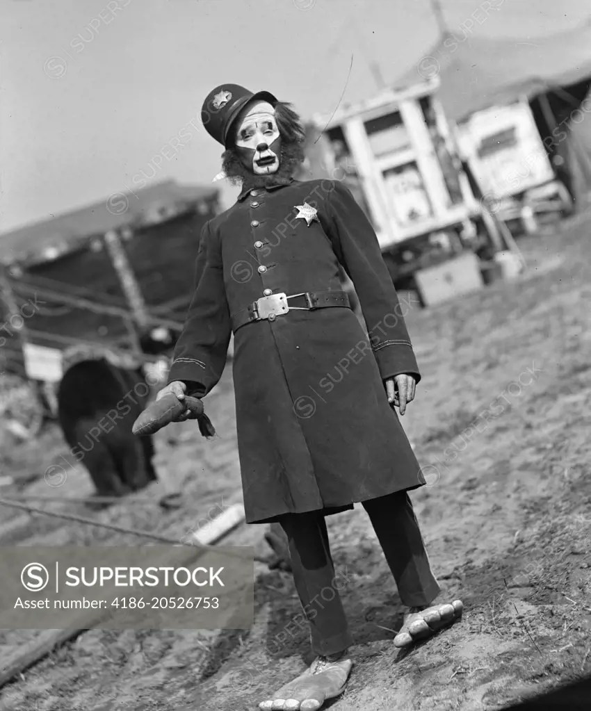 1920s 1930s CIRCUS PERFORMER CLOWN DRESSED AS KEYSTONE COP LOOKING AT CAMERA