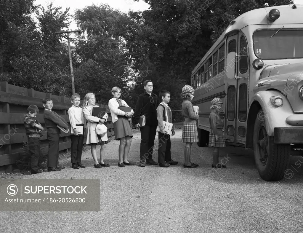 1960s ROW OF CHILDREN WAITING TO GET ON SCHOOL BUS