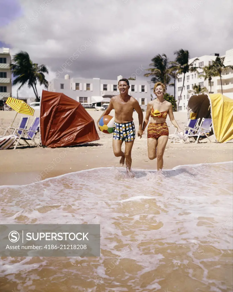 1950s 1960s HAPPY COUPLE ON TROPICAL BEACH FLORIDA USA