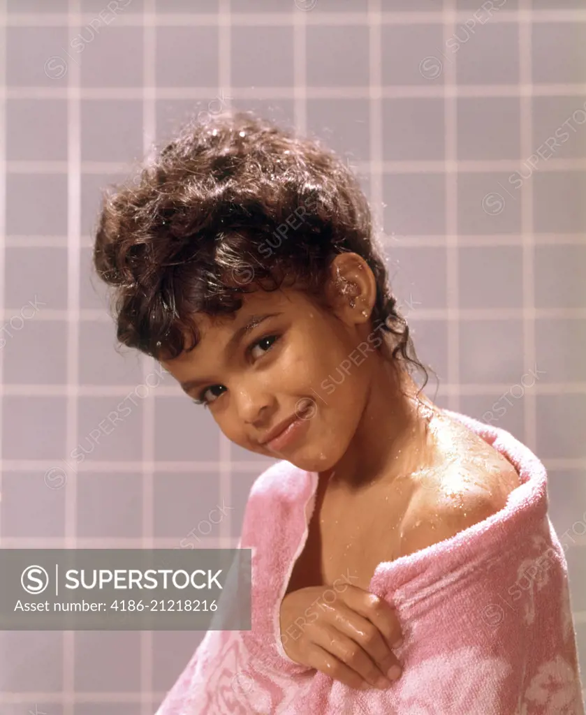 1970s SMILING AFRICAN AMERICAN TEENAGE GIRL WRAPPED IN SHOWER BATH TOWEL LOOKING AT CAMERA