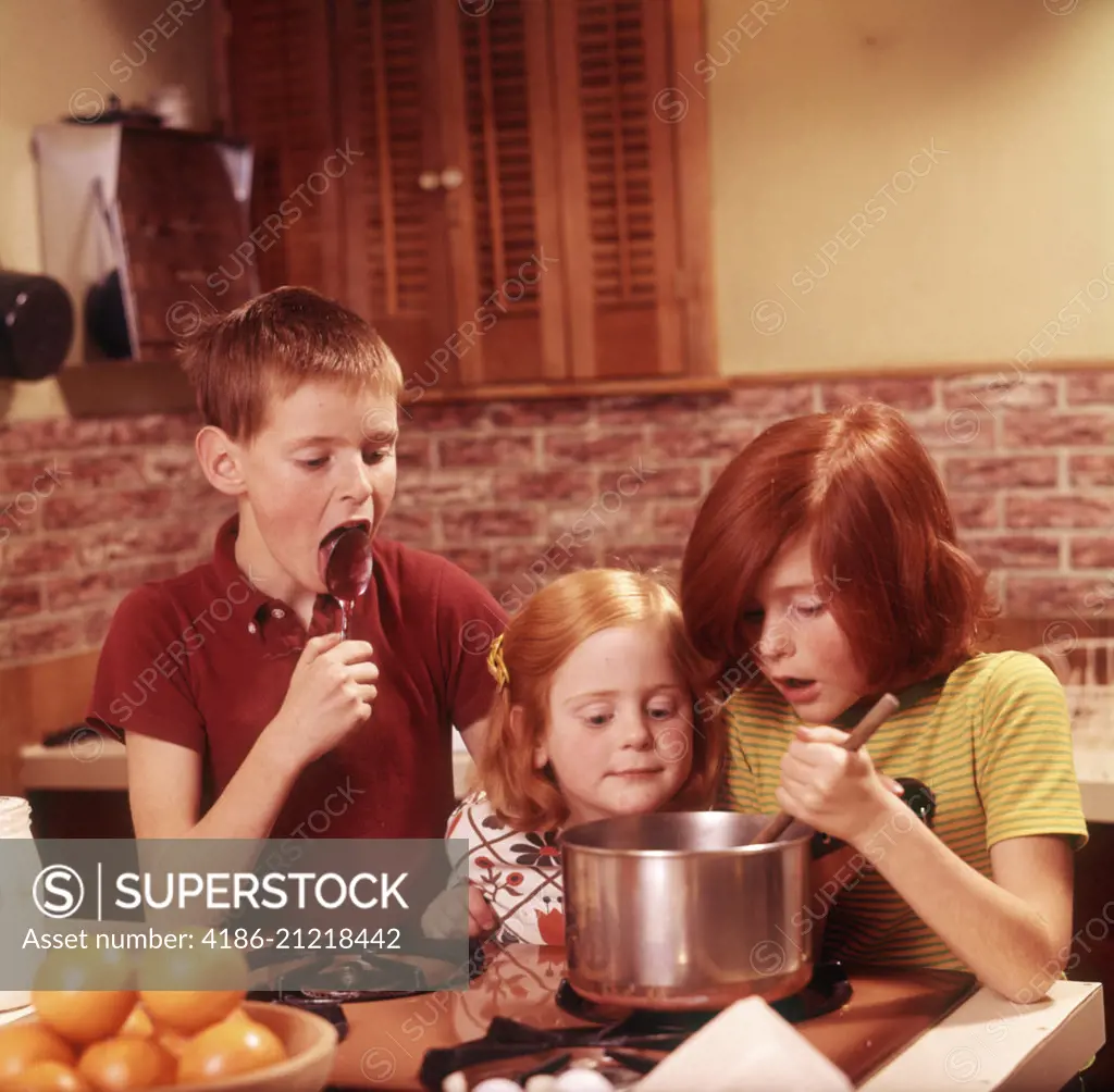 1970s 3 KIDS GIRLS BOY MAKING FUDGE BOY LICKING SPOON GIRL STIRRING PAN ON STOVE