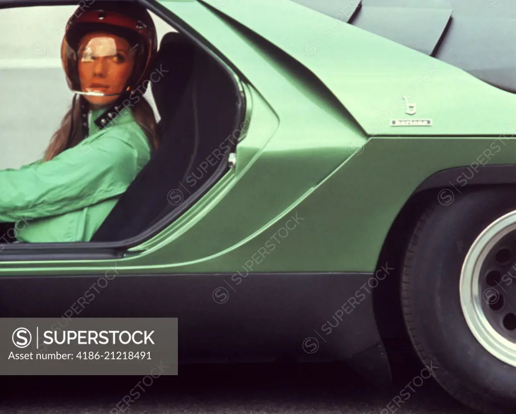 1970s YOUNG WOMAN WEAR HELMET GREEN SHIRT DRIVING GREEN ITALIAN SPORTS SPORT RACE RACING CAR JET SET