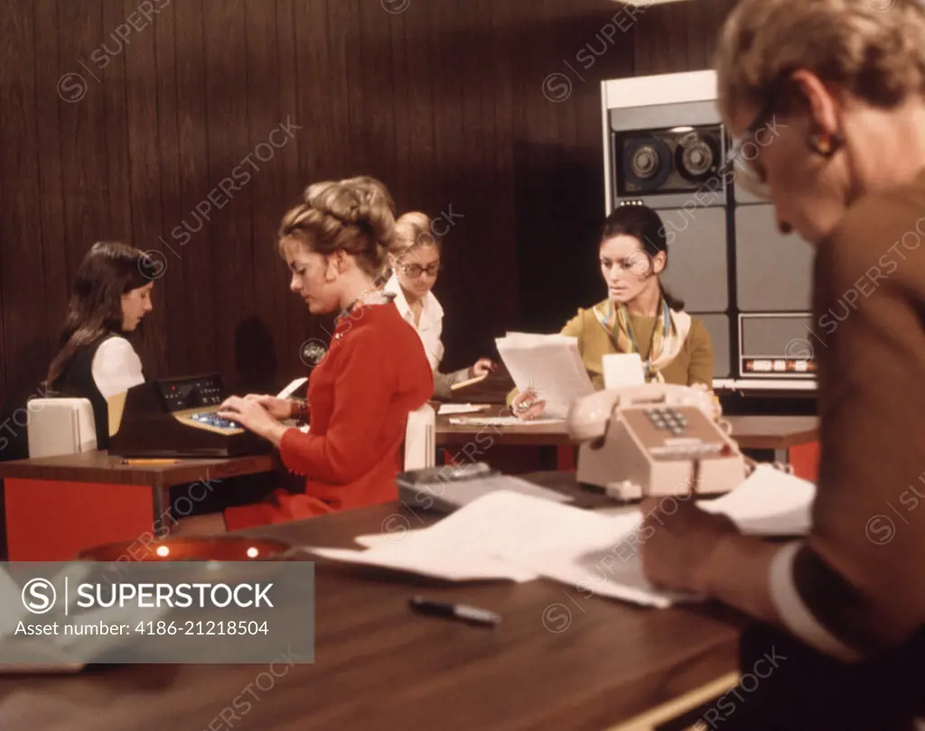 1970s 5 WOMEN OFFICE WORKERS DESKS COMPUTER MAINFRAME TELEPHONE PAPERS SECRETARY SECRETARIES WORK