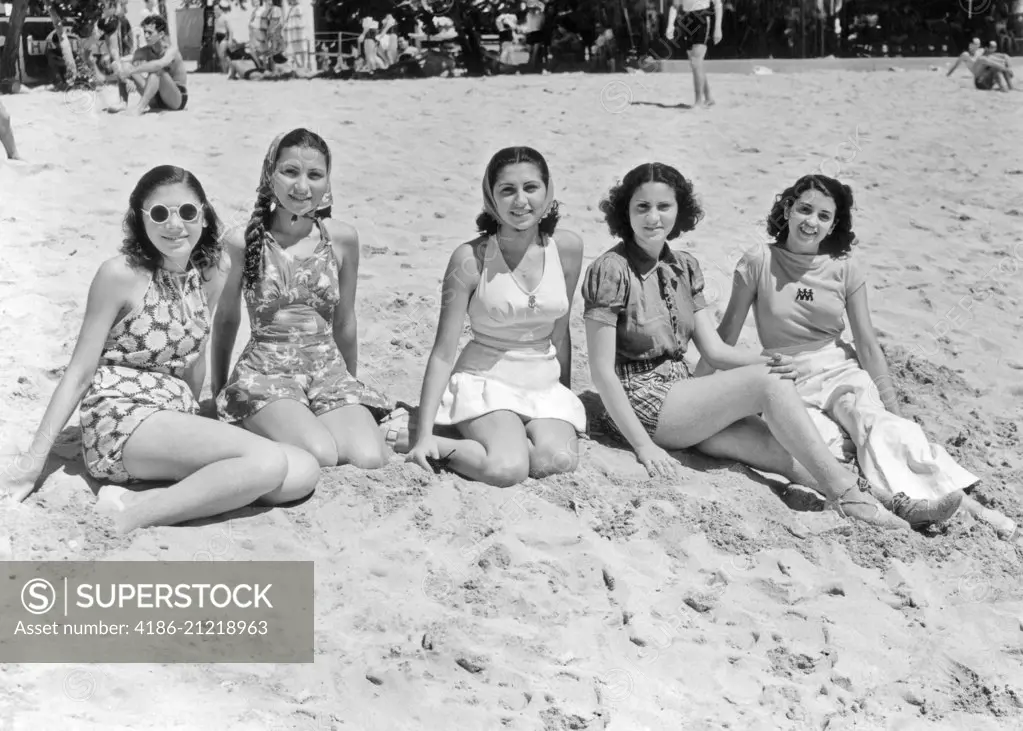 1930s 1940s FIVE SMILING WOMEN IN BEACH CLOTHES SITTING IN THE SAND LOOKING AT CAMERA LA PLAYA HAVANA CUBA