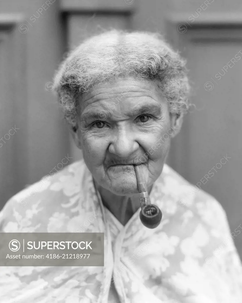 1940s PORTRAIT OF ELDERLY WOMAN LOOKING AT CAMERA SMOKING A PIPE HAVANA CUBA 