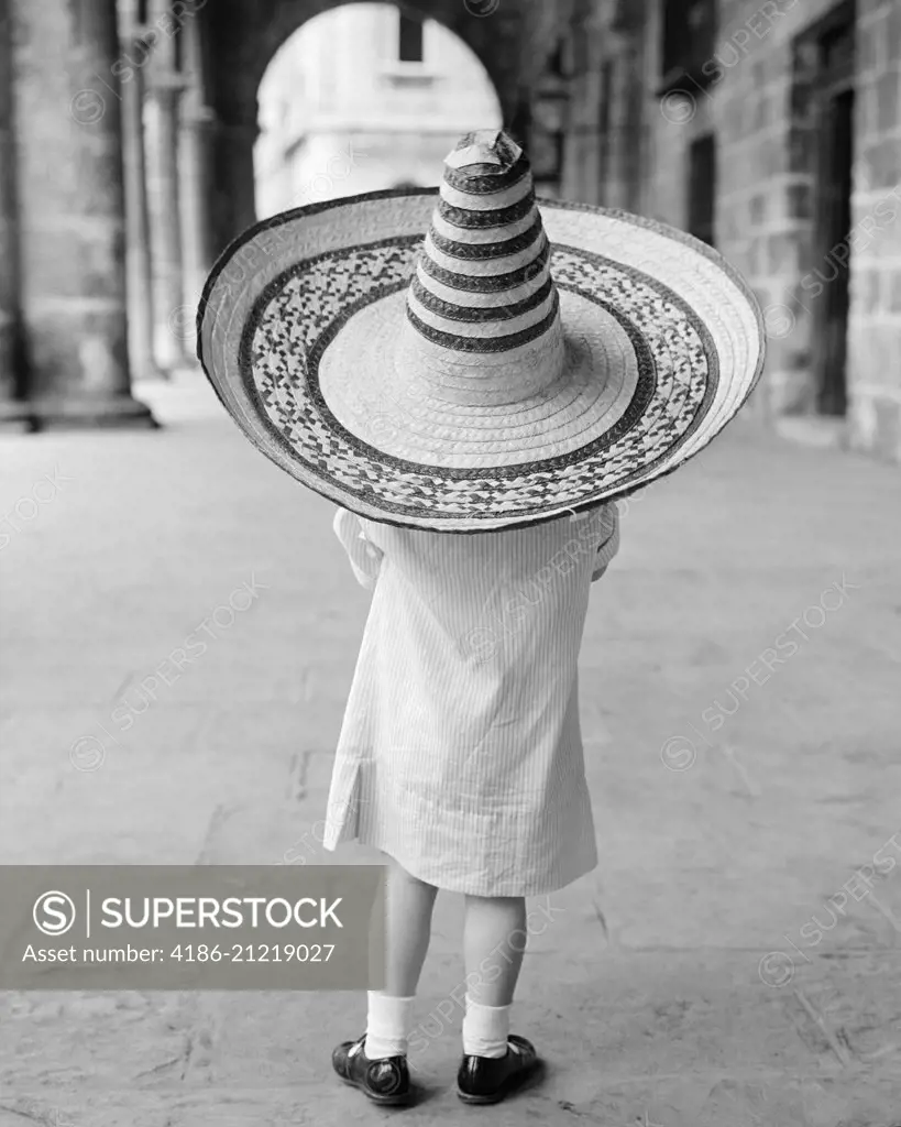 1950s 1960s SMALL GIRL TOURIST SEEN FROM BEHIND WEARING OVERSIZED TOO BIG STRAW HAT 