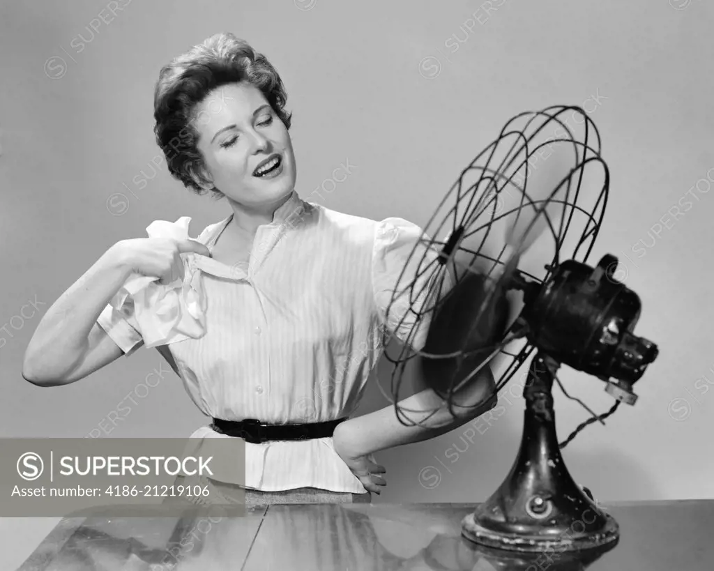 1950s WOMAN COOLING WITH SWIVEL FAN
