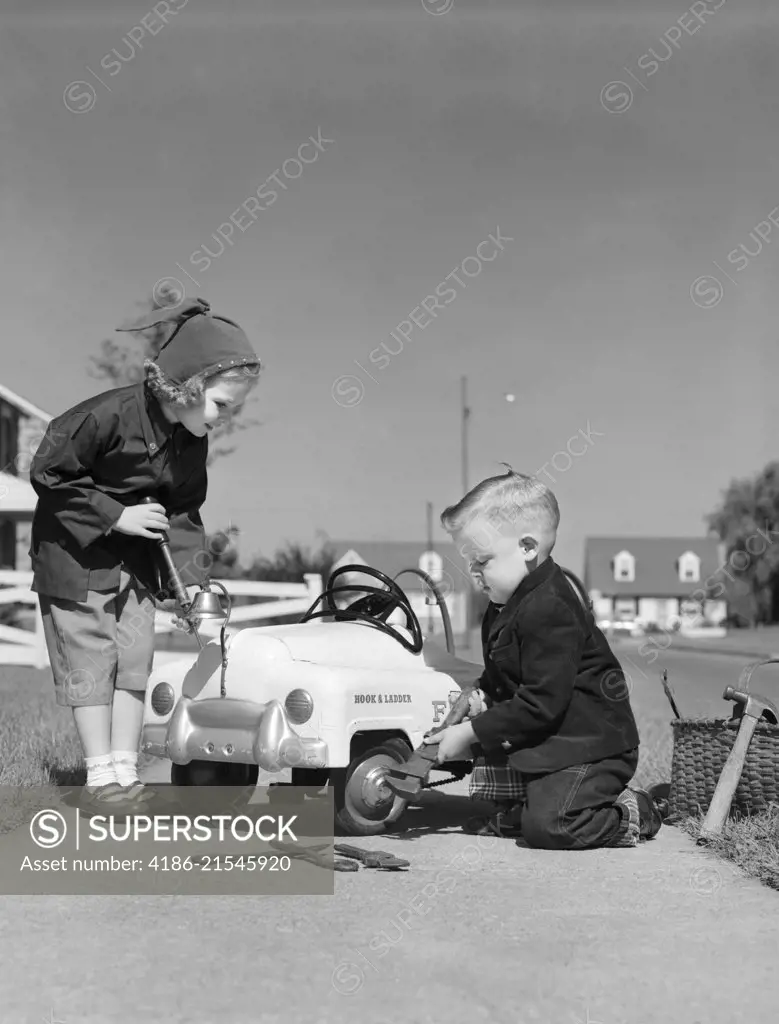 1930s TWO CHILDREN BOY AND A GIRL WORKING FIXING SERVICING A TOY PEDDLE CAR AUTOMOBILE