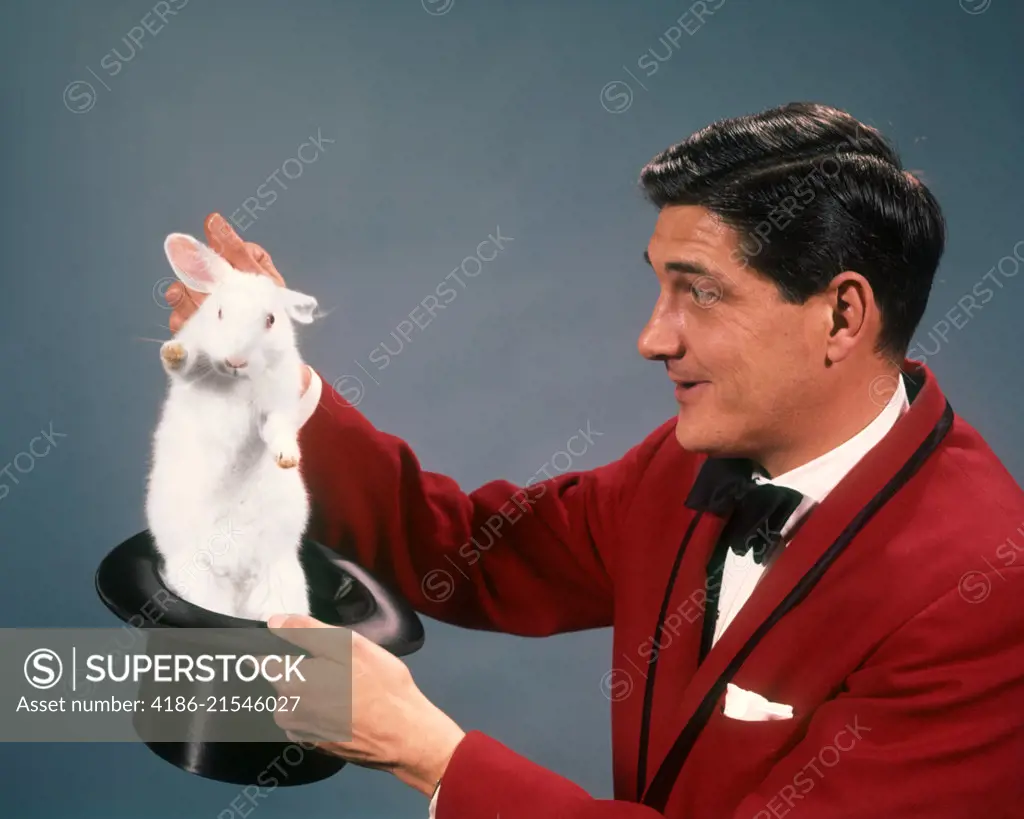  1960s 1970s MAN MAGICIAN WEARING RED SUIT PULLING WHITE RABBIT OUT OF TOP HAT