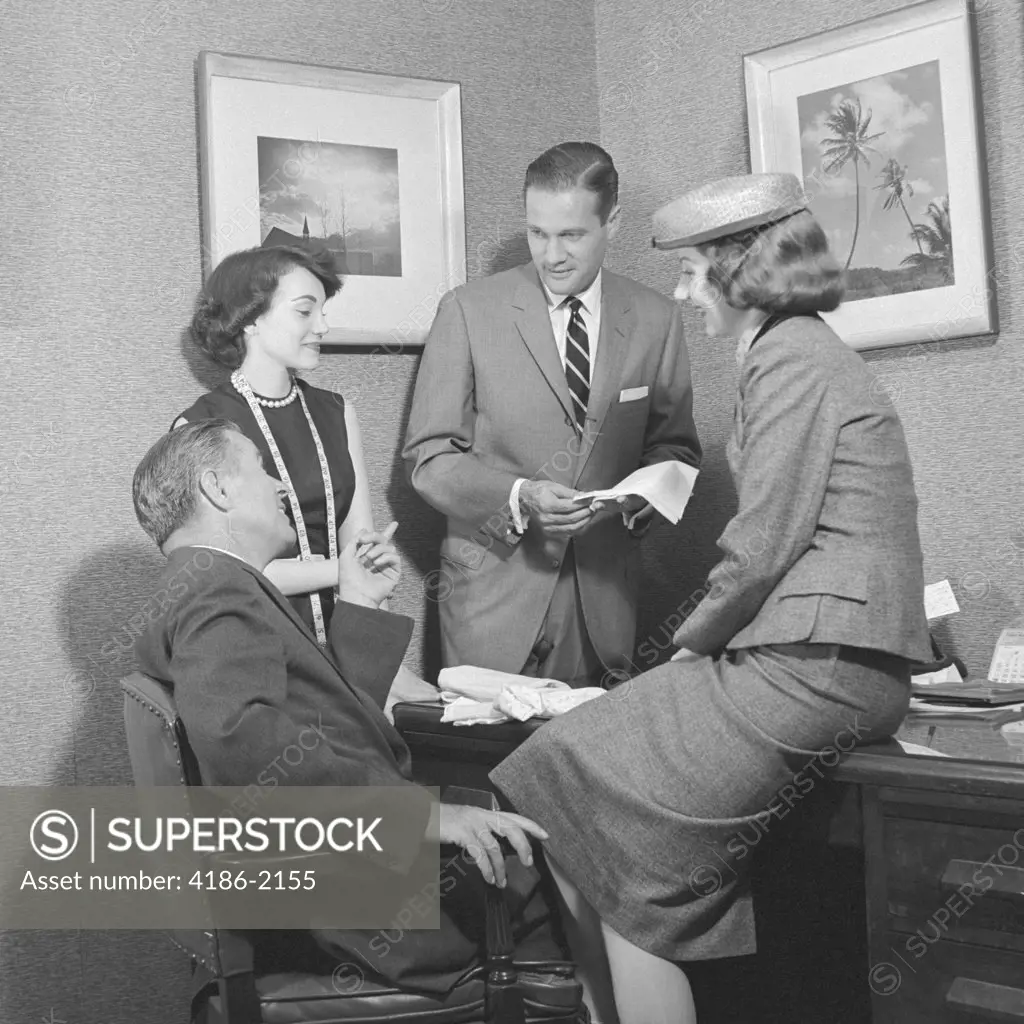1950S Two Men And Two Women Discussing Fabric Sample At Desk
