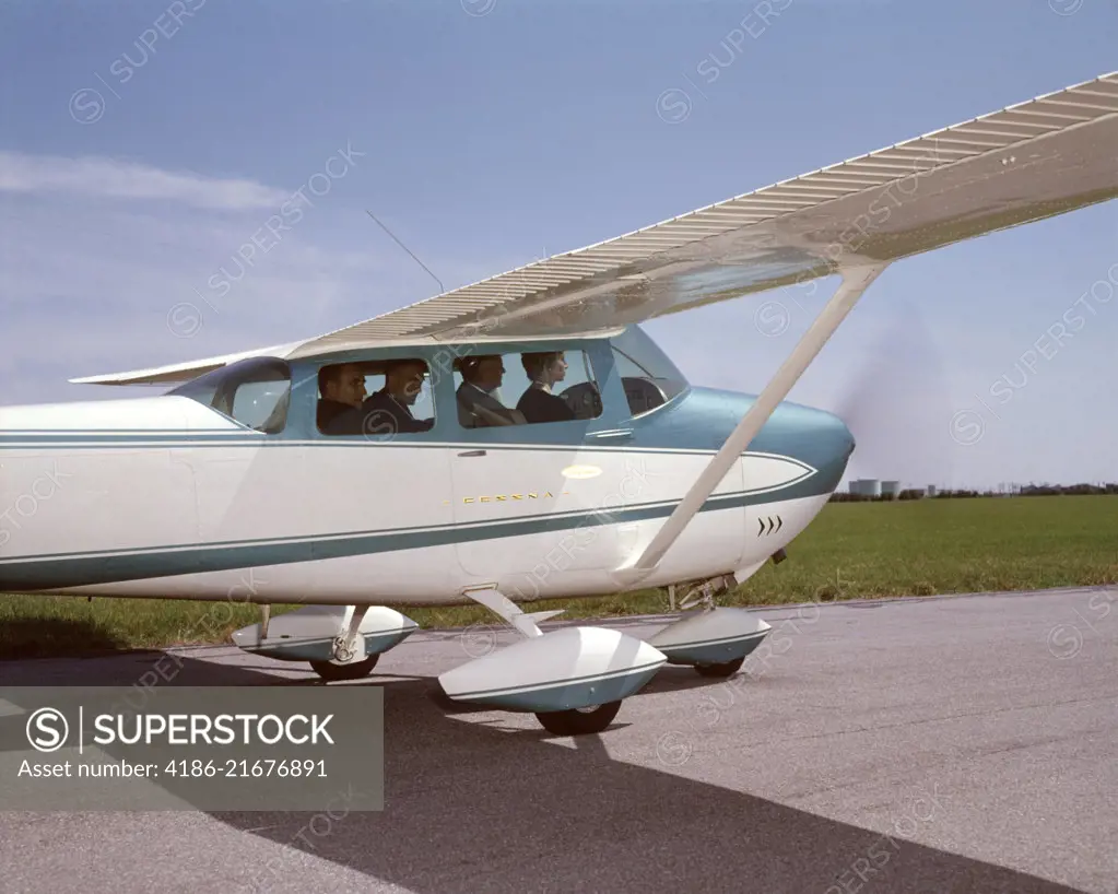 1960s FOUR BUSINESSMEN MEN EXECUTIVES SITTING IN CESSNA SKYLANE PRIVATE PROPELLOR AIRPLANE TAXING ON TARMAC RUNWAY