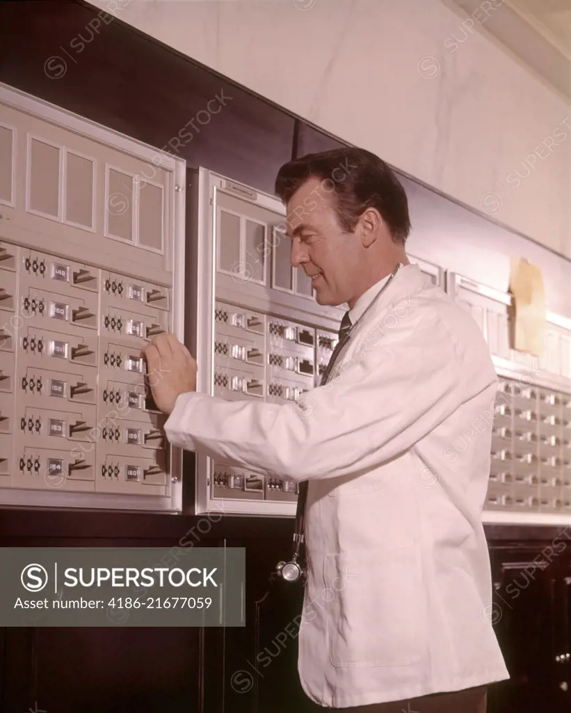 1960s MEDICAL DOCTOR RETRIEVING SUPPLIES FROM SECURE STORAGE