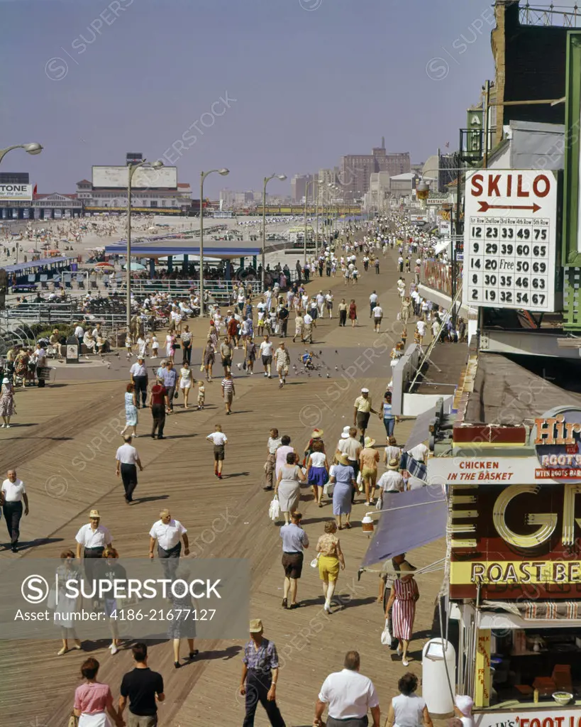 1960s FROM ABOVE LOOKING DOWN AT THE SHORE CROWD OF PEOPLE ON THE BOARDWALK OF BEACH RESORT ATLANTIC CITY NEW JERSEY USA