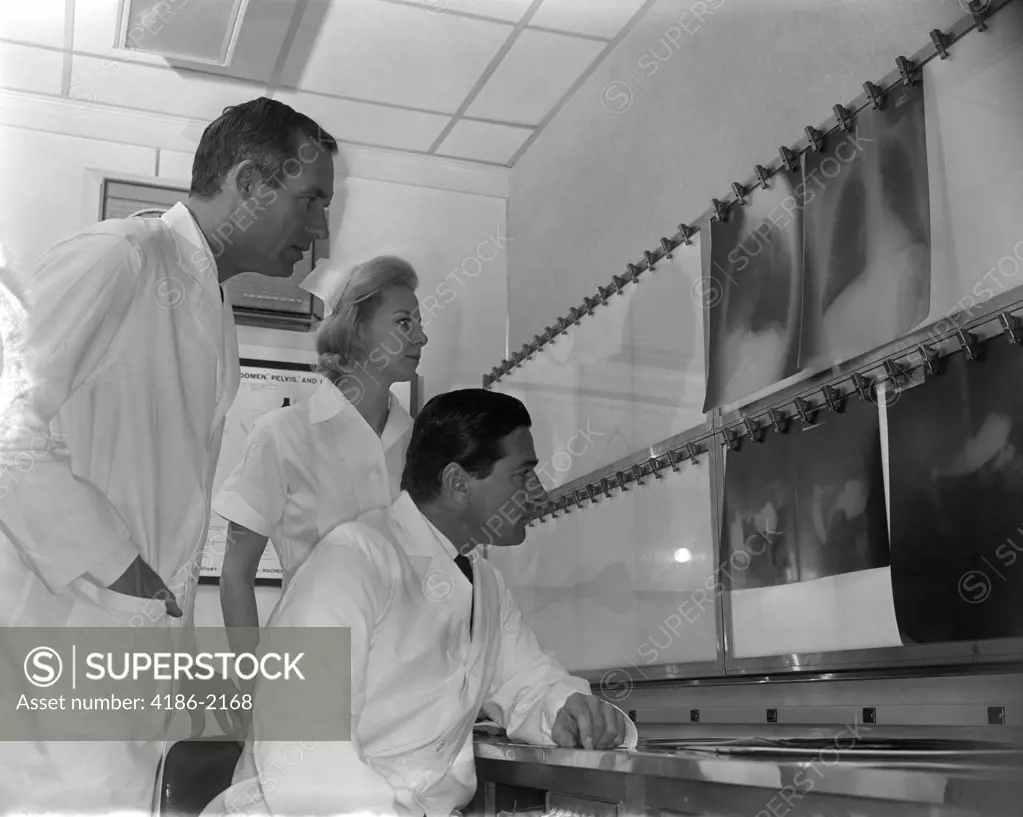1950S Two Doctors And Nurse Examining X-Rays