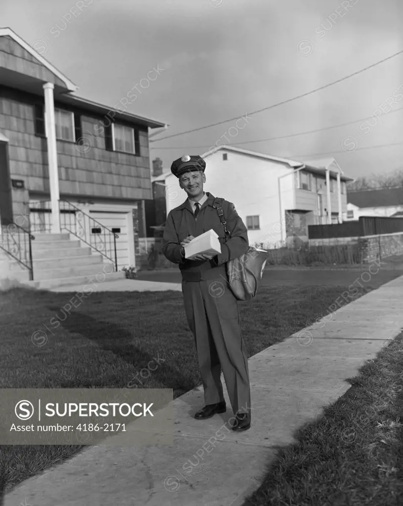 1960S Mailman Walking Outside Carrying Mail On Suburban Street