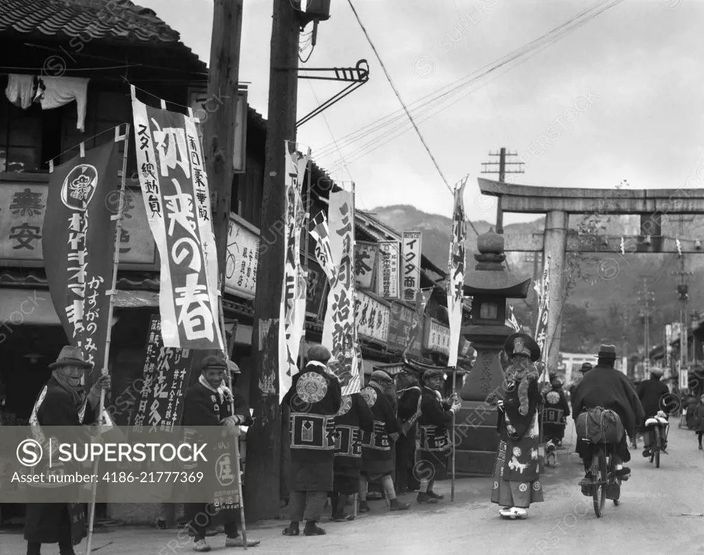 1930s GROUP OF MEN ADVERTISING AD PARADE TROOP HOLDING MARKETING ADVERTISING SIGNS AND BANNERS KOBE JAPAN
