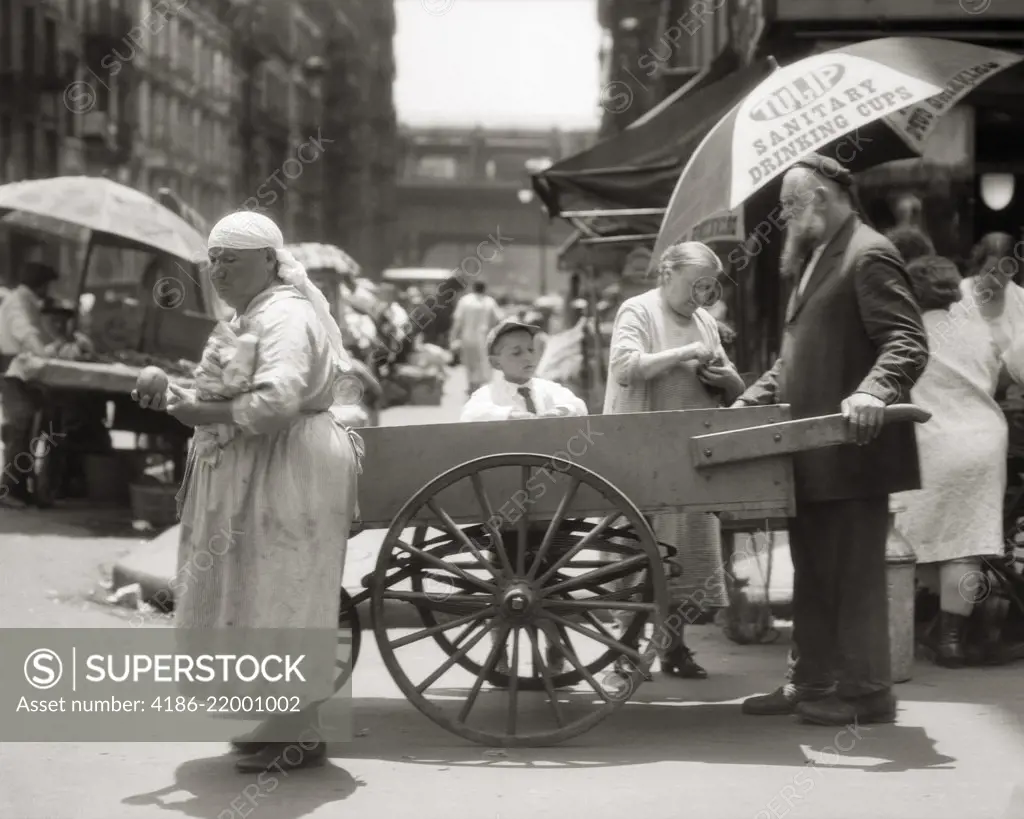 1930s DEPRESSION ERA LOWER EAST SIDE PUSHCART SCENE WITH EASTERN EUROPEAN IMMIGRANT VENDORS AND CUSTOMERS NEW YORK CITY USA
