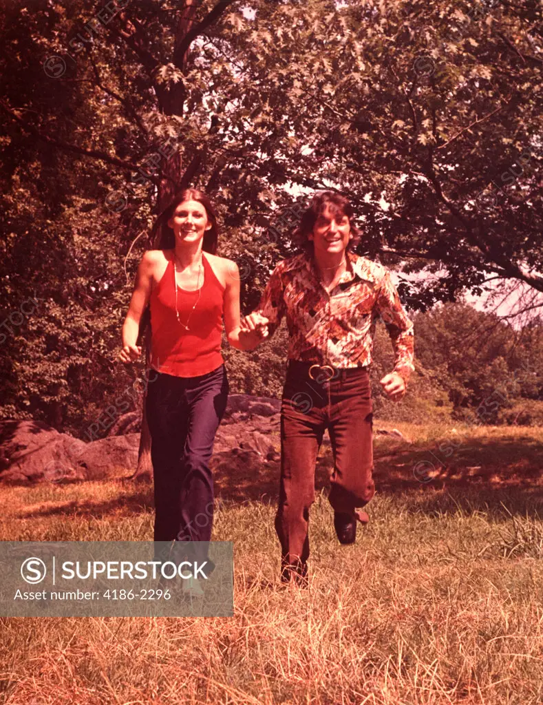 1960S Young Couple Running In Field