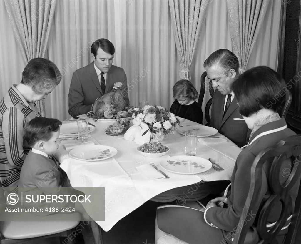 1960S Three Generation Family Saying Grace Prayer At Thanksgiving Turkey Dinner