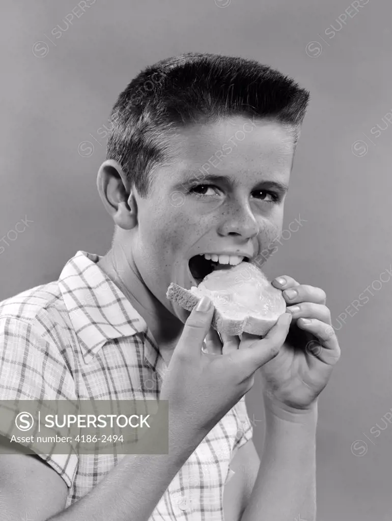 1950S Boy With Crew Cut Eating A Slice Of Bread