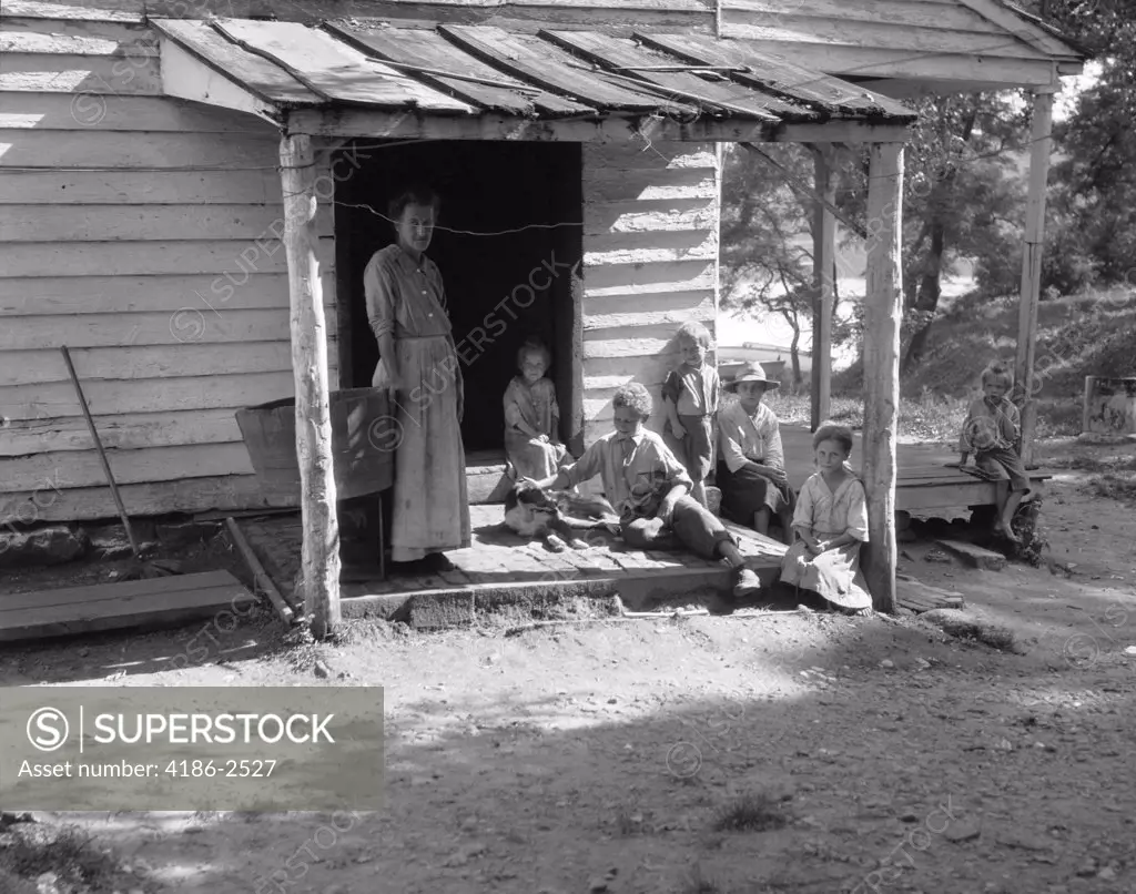 1930S 1940S Farm Woman With Six Children On Porch Of Clap Board Farm House 