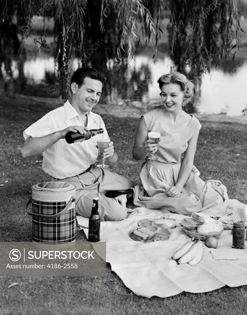 1950S Man Woman Couple Having A Summer Picnic Outdoors Drinking Beer