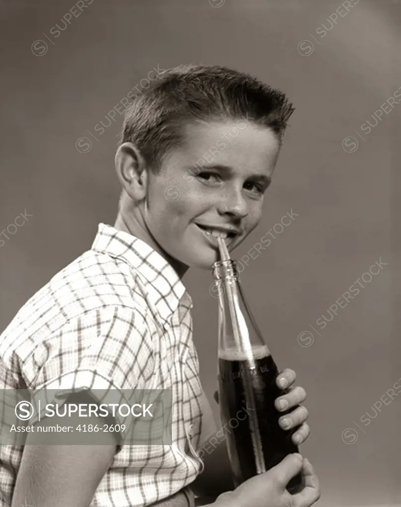 1950S Smiling Boy Drinking Carbonated Beverage From Soda Pop Bottle With Straw