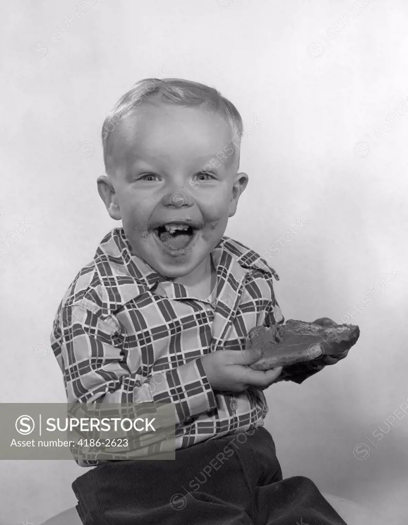 1950S Laughing Boy Wearing A Plaid Shirt With Jam On His Face And Mouth Holding A Slice Of Bread And Jam With Both Hands