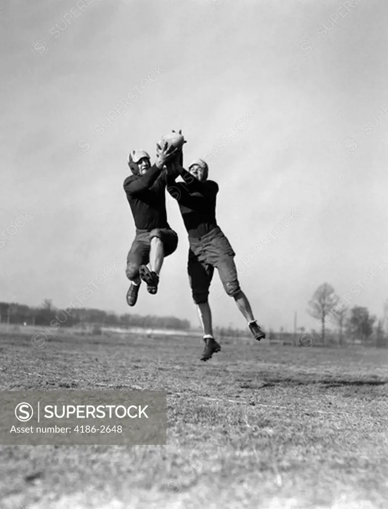 1930S Two Football Players Jumping To Catch Ball Pass Interception