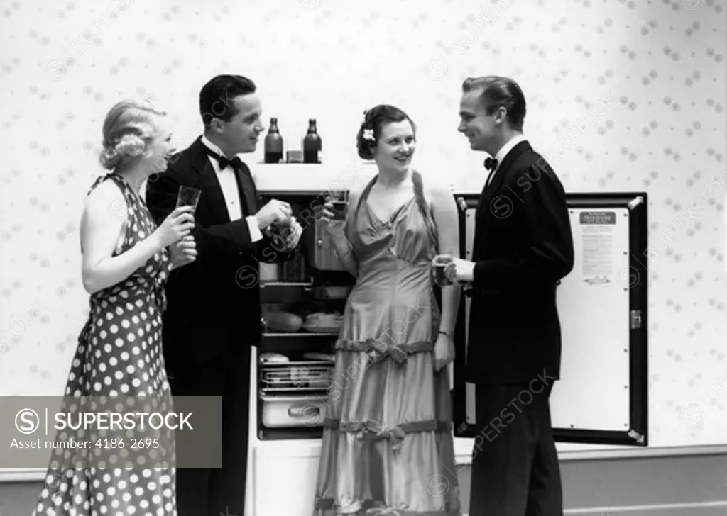 1930S 1940S Two Couples Formally Dressed Standing In Front Of Refrigerator With Doors Open Drinking Beer