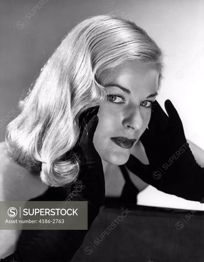 1950S Portrait Of Glamorous Blond Woman With Long Black Gloved Hands Touching Cheek