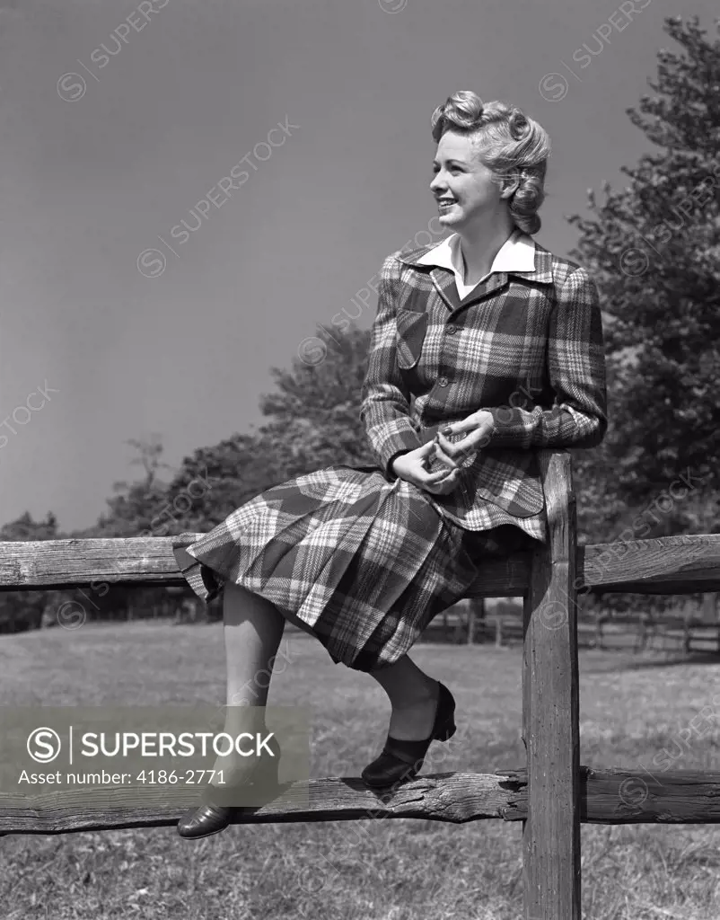 1940S Full Length Portrait Of Blond Woman Sitting On A Wooden Fence Wearing Plaid Tartan Suit