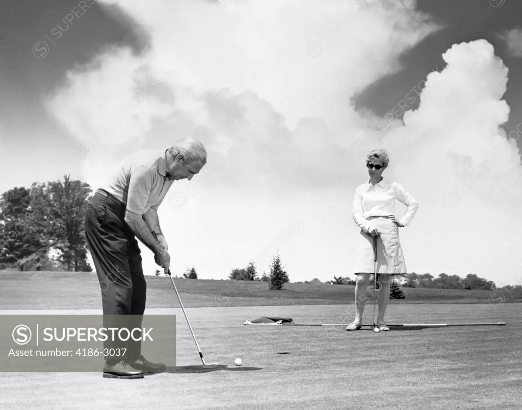1960S Older Couple Putt Putting On Golfing Green