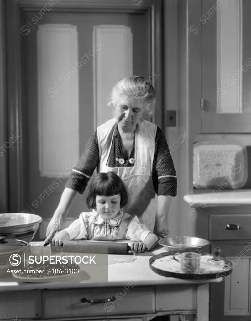 1920S 1930S Grandmother Baking Cherry Pie Teaching Granddaughter To Use Rolling Pin