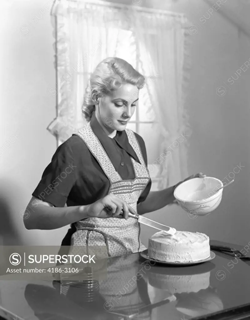 1940S Woman In Kitchen Wearing Apron Frosting Cake Indoor