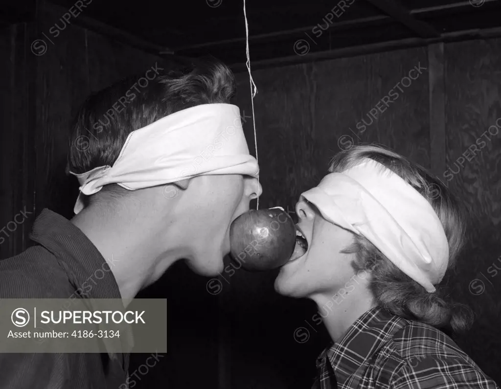 1950S Blindfolded Teenage Couple Boy Girl Trying To Eat An Apple Hanging On A String
