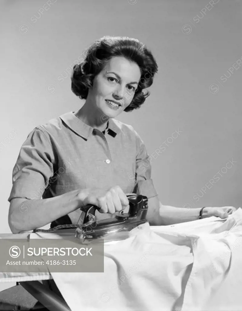 1950S Smiling Woman Housewife Ironing Shirt Looking At Camera
