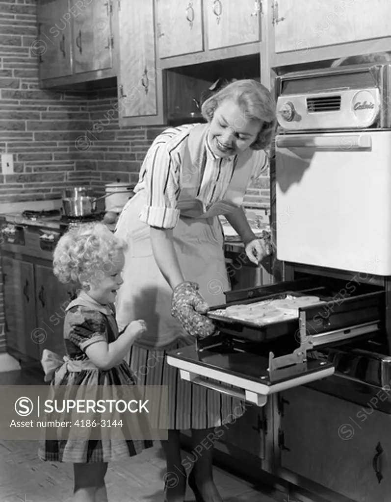 1950S Smiling Mother Daughter In Kitchen Broiling Pork Chops