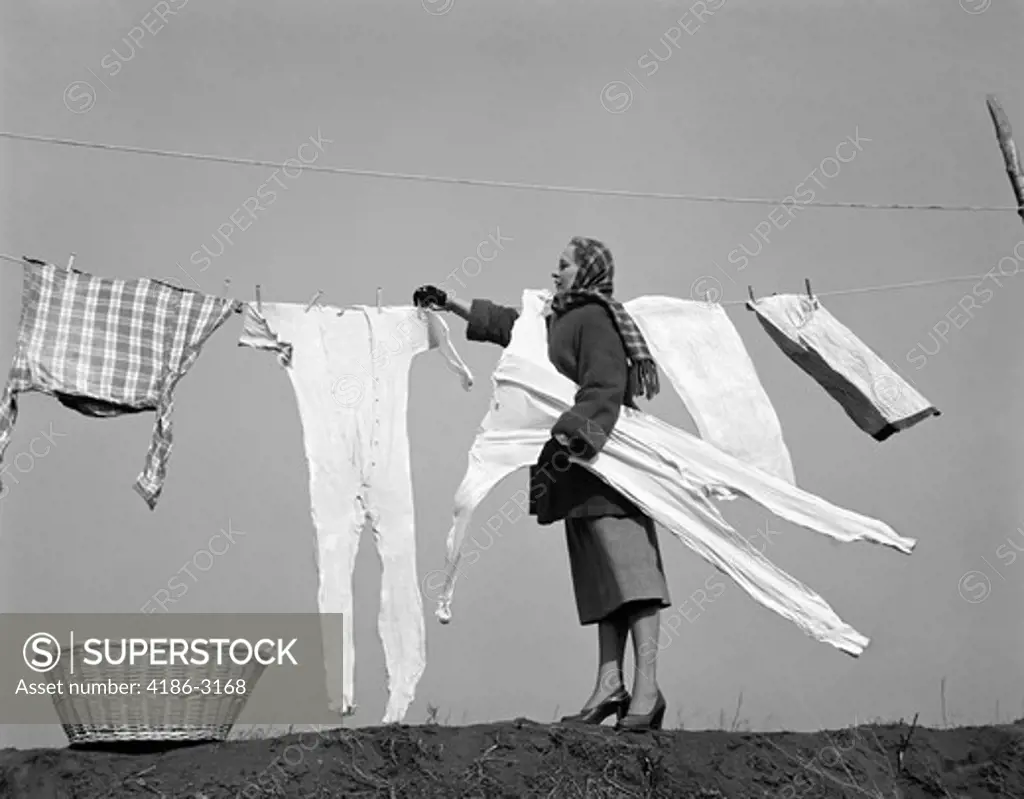 1950S Housewife Removing Frozen Long Johns From Clothesline