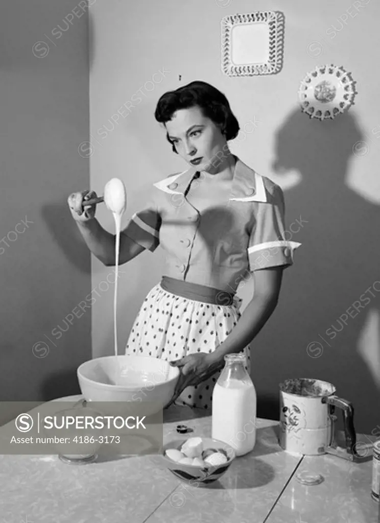 1960S Housewife Mixing Sticky Batter In Kitchen