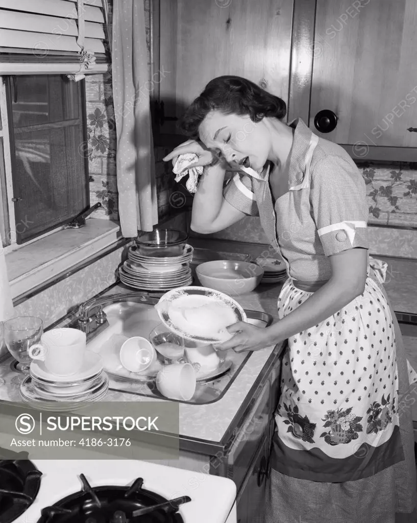 1950S Tired Exhausted Woman Housewife In Kitchen With Sink Full Of Dirty Dishes