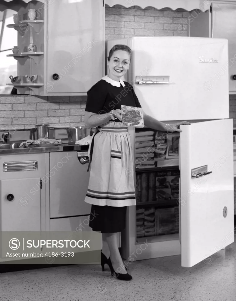 1950S Smiling Woman Housewife In Kitchen Taking Frozen Food Out Of Refrigerator Freezer