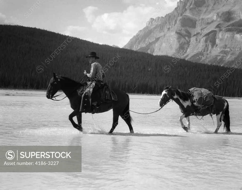 1940S Cowboy On Horseback Crossing River With 2Nd Horse In Tow
