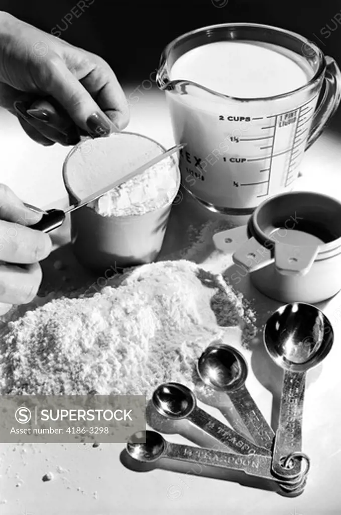 1950S 1960S 1970S Woman'S Hand Leveling Off Flour In Measuring Cup For Baking