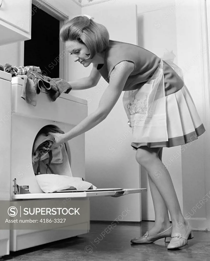 1970S Woman Removing Laundry From Dryer  