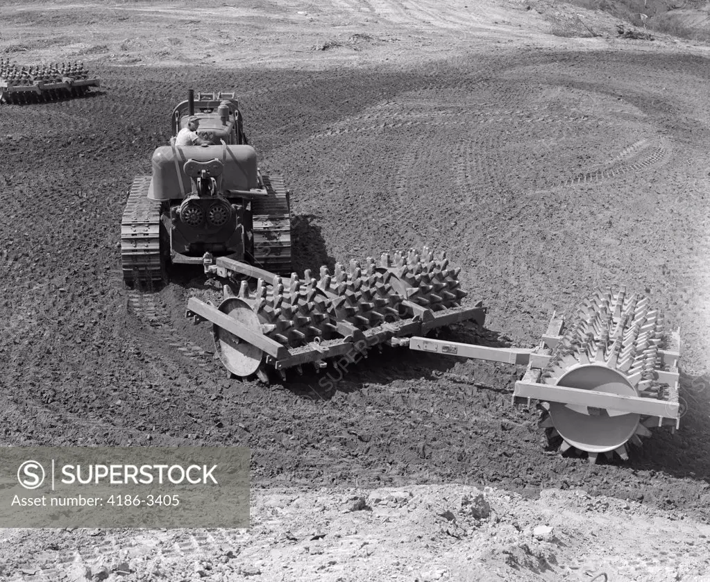 1960S Man Operating Grading Machine In Soil Construction Site Heavy Machinery Attachment Roller With Spikes