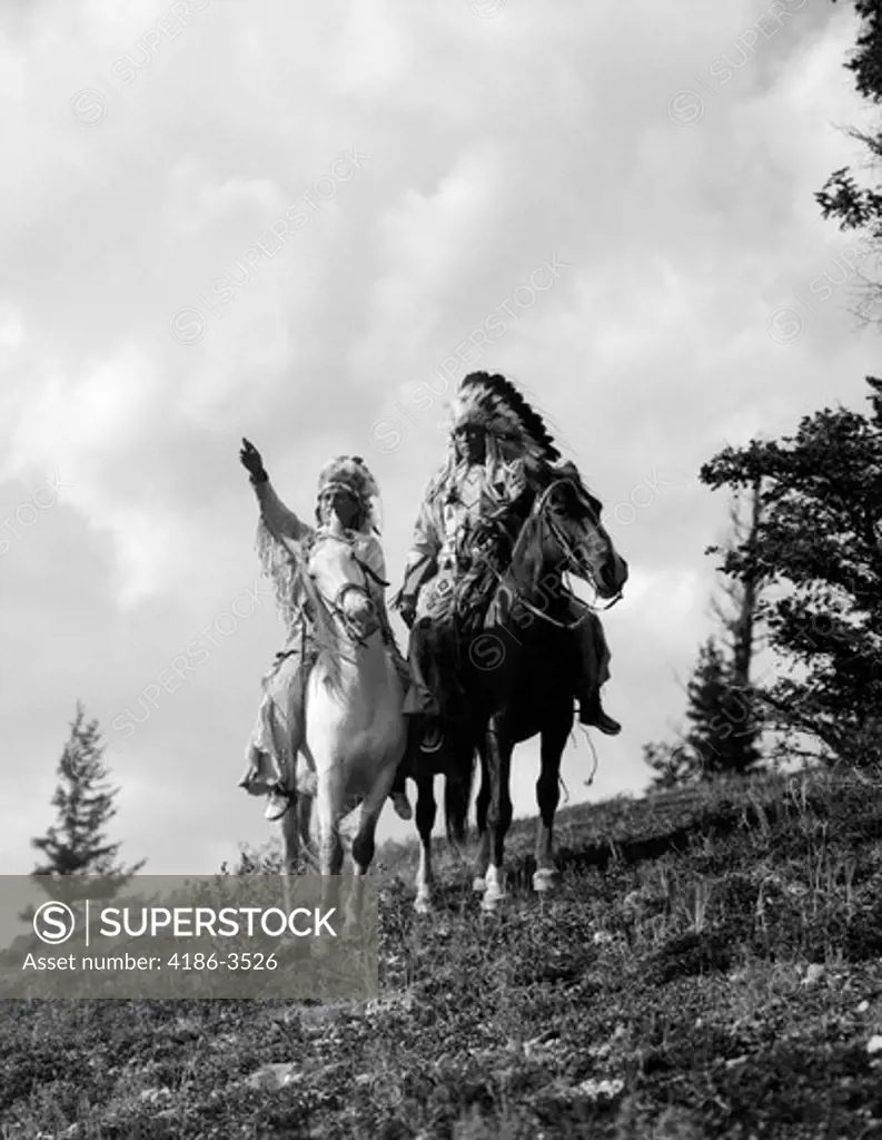 1930S Pair Of Sioux Indians In Headdresses On Horseback Pointing Out Trail