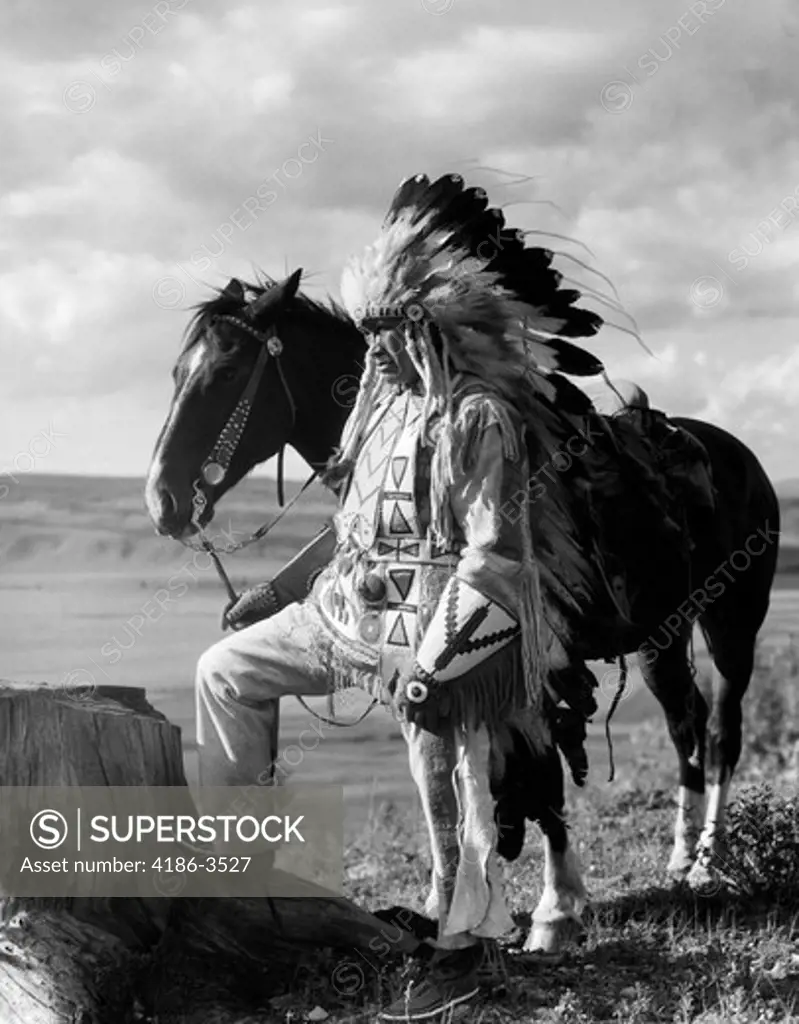1930S Portrait Sioux Indian Man Wearing Feather Headdress Holding Reins Of Horse