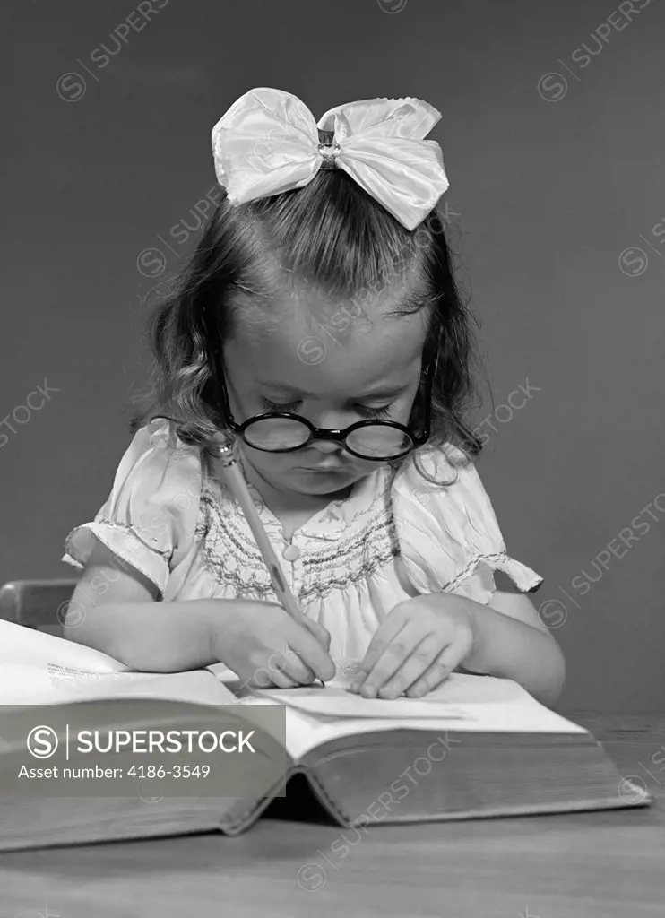 1940S Girl With Big Round Glasses And A Big White Ribbon Bow In Hair Copying From A Book With A Pencil School Studio
